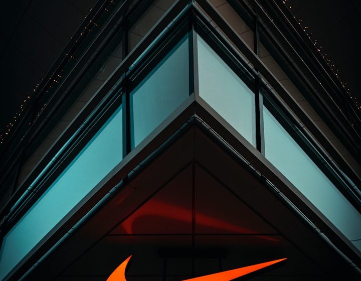 Logotipo de Nike en la esquina de un edificio moderno iluminado.