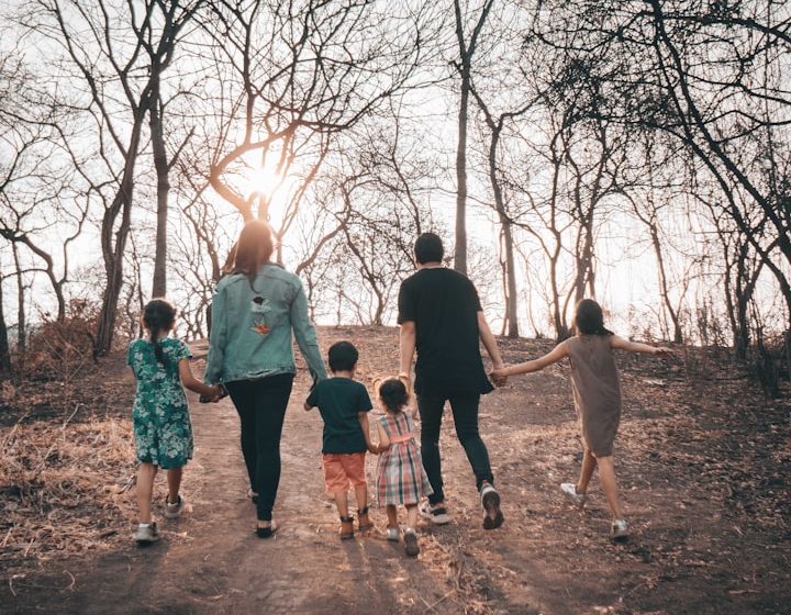 Grupo de seis personas caminando por un sendero en un paisaje seco y soleado.